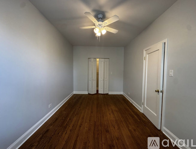A room with wooden floors and a ceiling fan.
