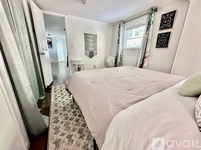 A bedroom with a large bed and a rug on the floor.