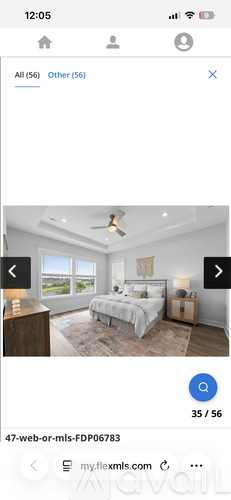 A bedroom with a large bed and a ceiling fan.