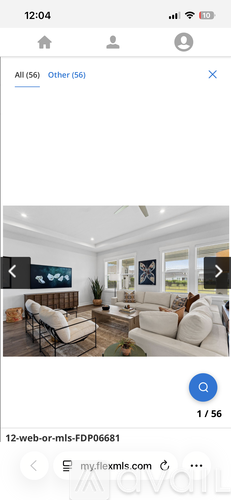A modern living room with white furniture and a large window.