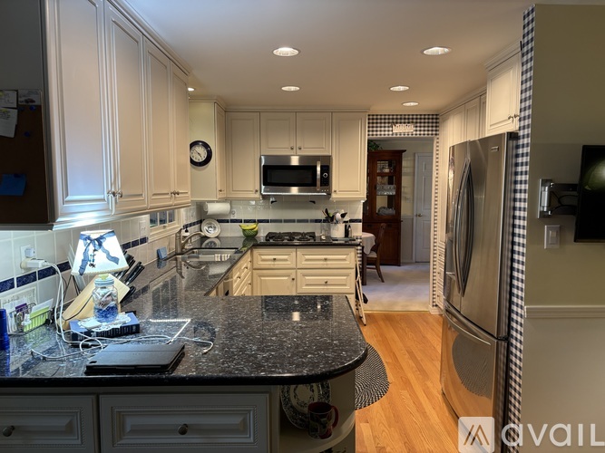 A kitchen with a black granite countertop and white cabinets.
