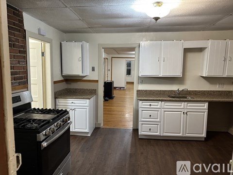 A kitchen with white cabinets and a black stove top oven.