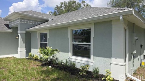 A house with a grey roof and white walls.