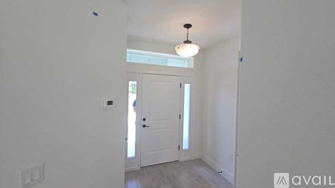 A room with a white door and a light on the ceiling.