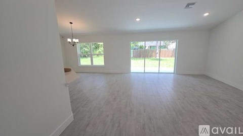 A spacious room with a large window and sliding glass doors.