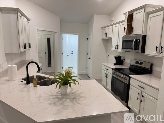A kitchen with white cabinets and a marble countertop.