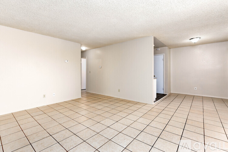 Empty room with tile flooring and white walls.