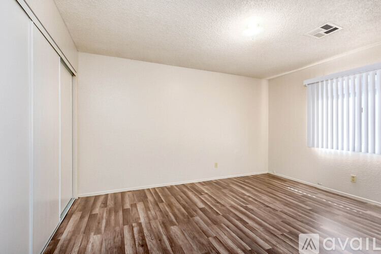 A room with wooden flooring and white walls.