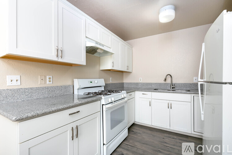 A kitchen with white cabinets and appliances.