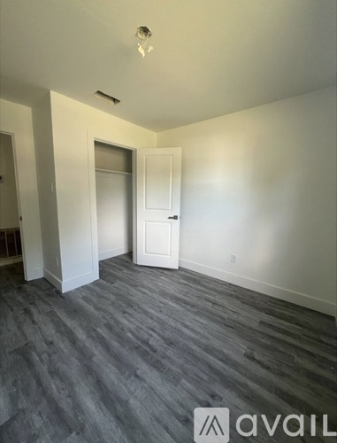 A room with a grey carpet and a white door.