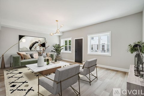 A living room with a sofa, two chairs, a coffee table, and a rug.
