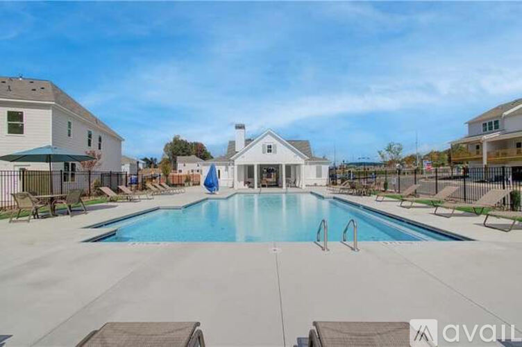 A large swimming pool surrounded by lounge chairs and buildings.