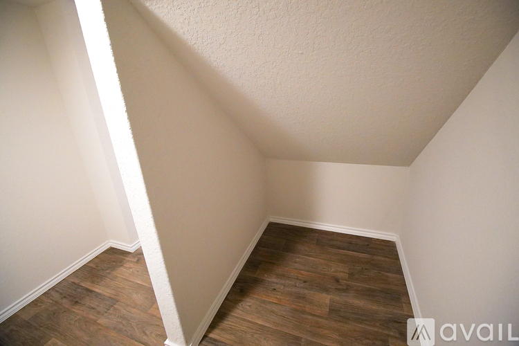 A room with wooden flooring and white walls.