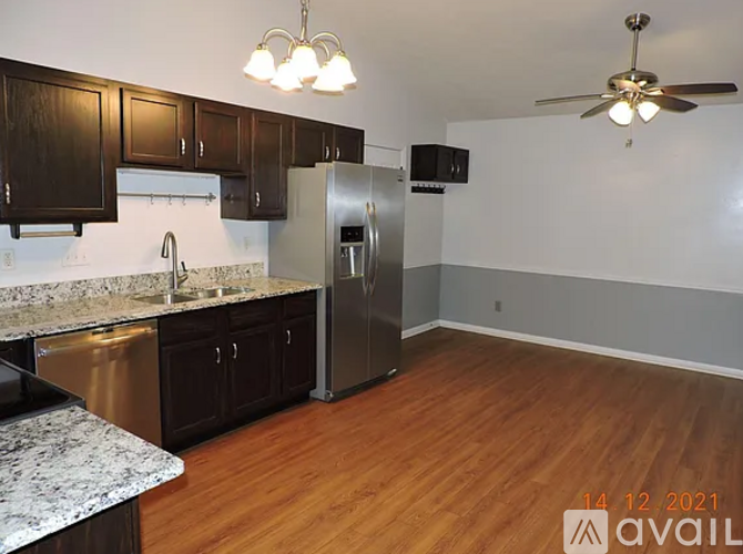 A kitchen with wooden cabinets and a stainless steel refrigerator.