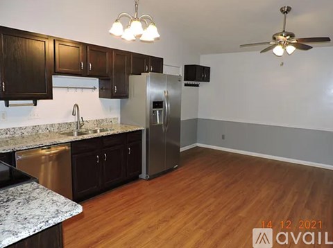 A kitchen with wooden cabinets and a stainless steel refrigerator.