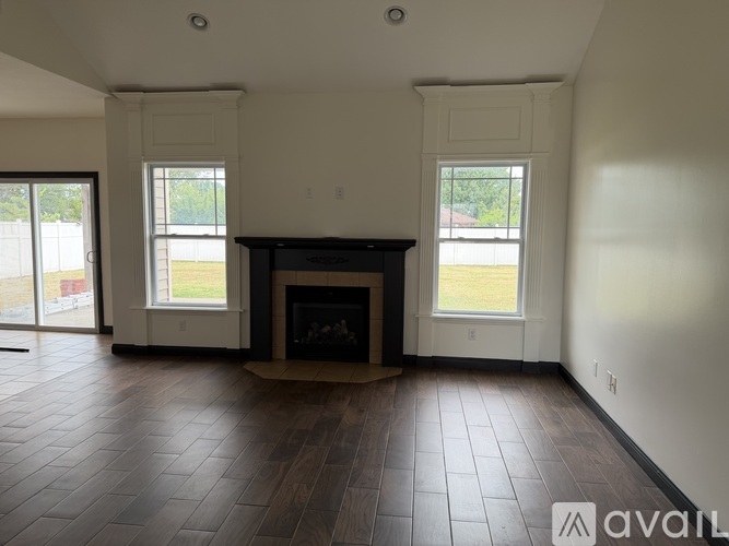 A living room with a fireplace and large windows.