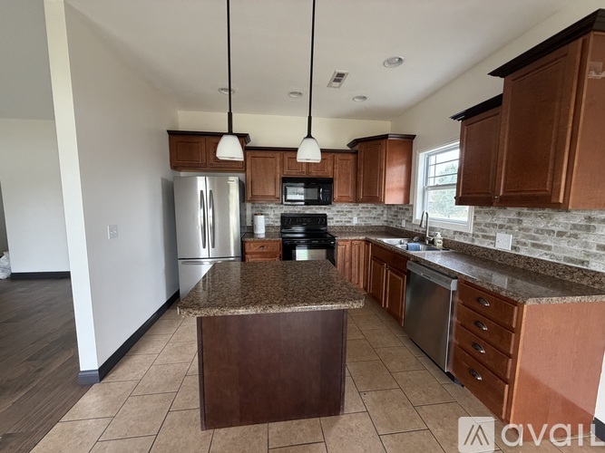 A kitchen with brown cabinets and a granite countertop.