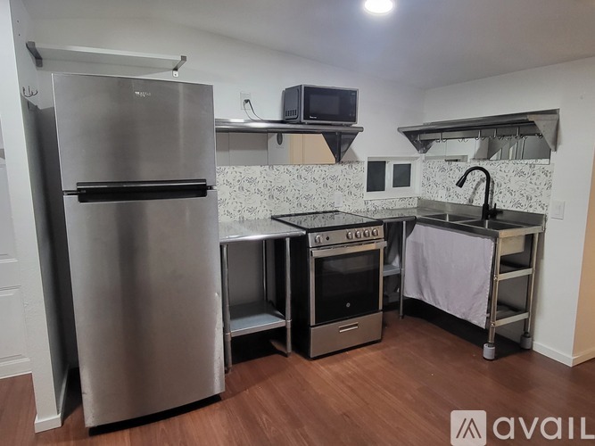 A kitchen with a stainless steel refrigerator, a stove, and an oven.