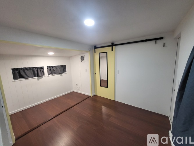 A room with a wooden floor and a yellow door.