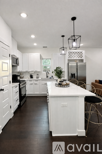 A modern kitchen with white cabinets and a large island.