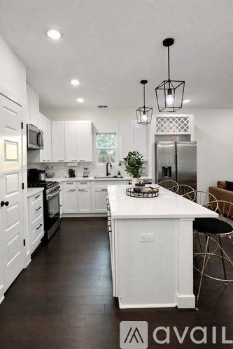 A modern kitchen with white cabinets and a large island.