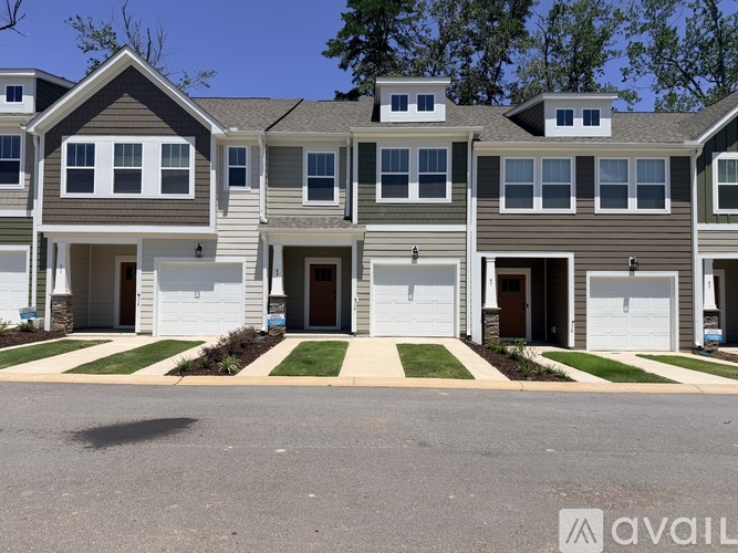 A row of houses with the first one having a white garage door.