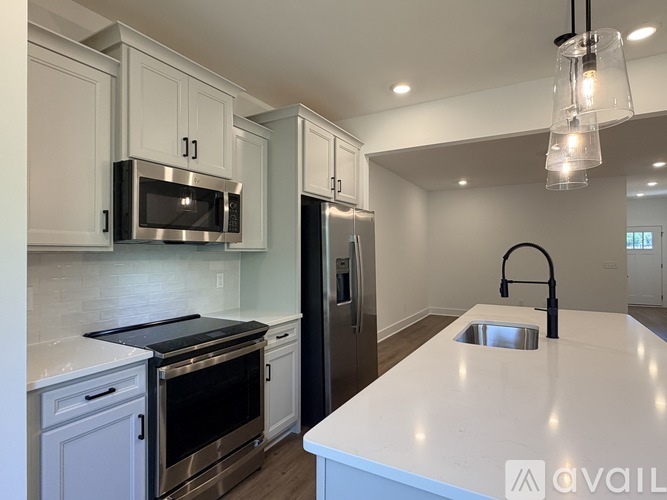 A kitchen with white cabinets and a white countertop.