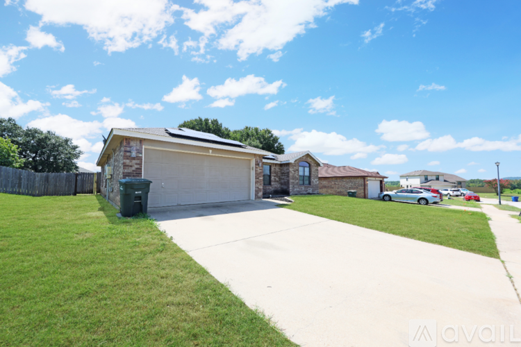 A house with a garage and a driveway in front of it.