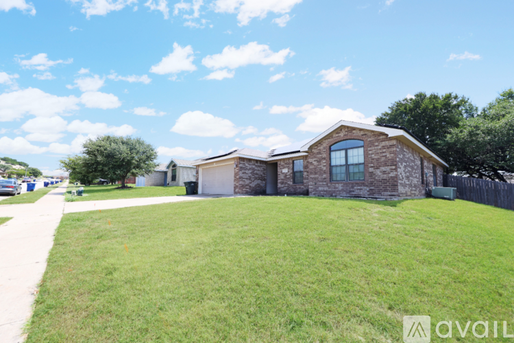 A house with a fence and a grassy yard is available for sale.