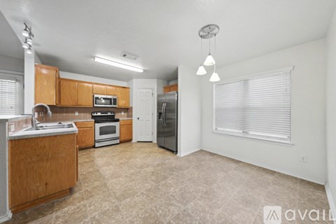 A kitchen with wooden cabinets and a tiled floor.