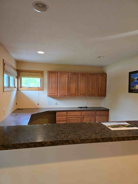 A kitchen with wooden cabinets and a granite countertop.