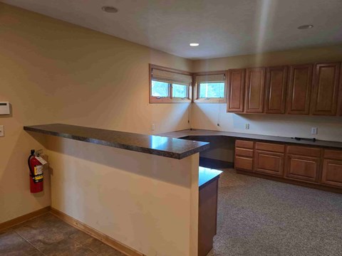 A kitchen with a black countertop and wooden cabinets.