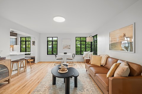 A living room with a brown leather couch and a black coffee table.