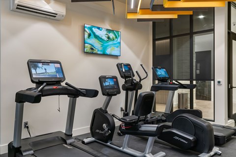 A gym with treadmills and exercise bikes.