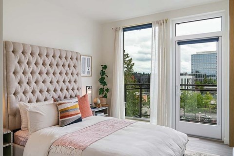 A bedroom with a large bed and a view of the city.