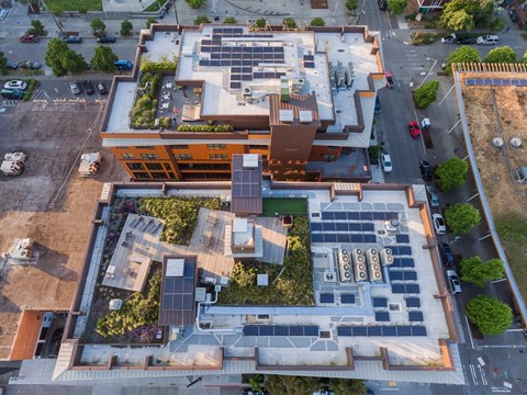 A large building with a lot of windows and a green roof.