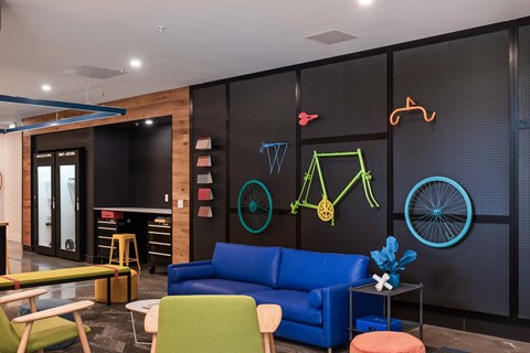 A modern living room with a blue couch and a neon sign.
