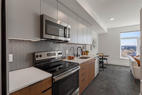 A modern kitchen with a stove top oven and microwave above it.