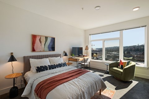 A bedroom with a large bed and a view of the city.