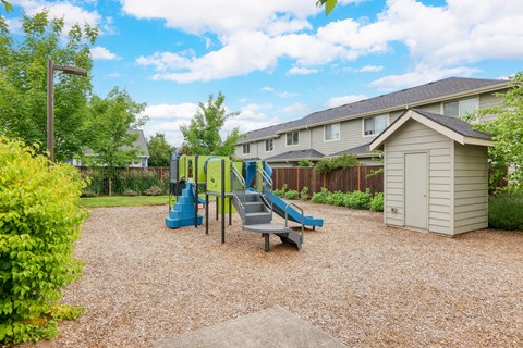 A playground with a blue slide and a grey slide.