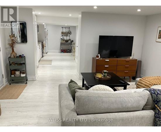 A living room with a grey couch and a wooden cabinet.