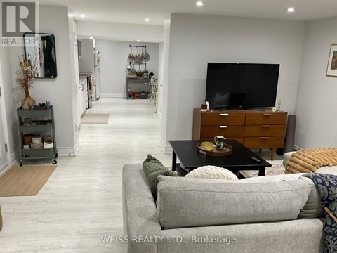 A living room with a grey couch and a wooden cabinet.