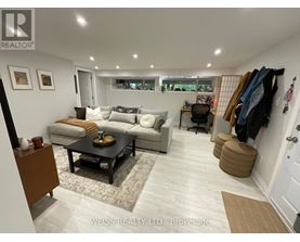 A well-lit living room with a couch, coffee table, and a wall-mounted coat rack.