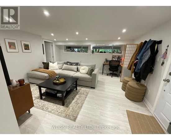 A well-lit living room with a couch, coffee table, and a wall-mounted coat rack.