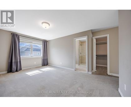 A spacious room with a window and a sliding door.