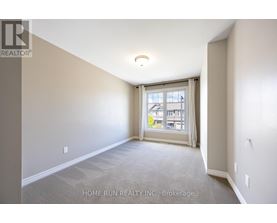 A room with a carpeted floor and a window with a view of a building outside.