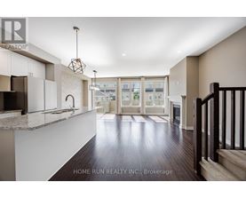 A spacious living room with a staircase on the right side.