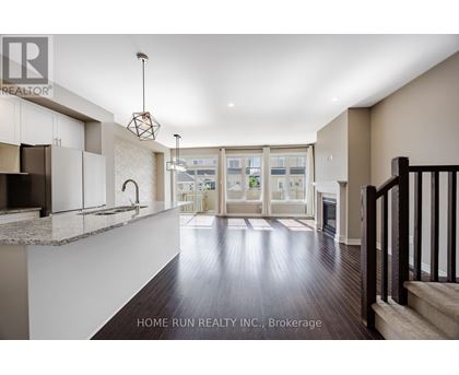 A spacious living room with a staircase on the right side.