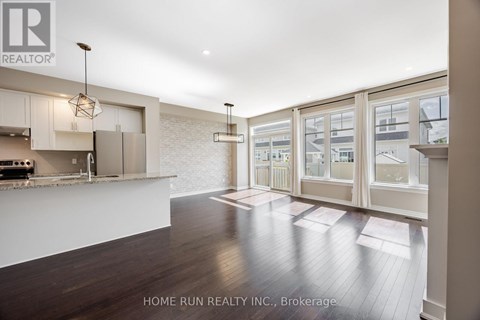 A modern kitchen with white cabinets and a wooden floor.