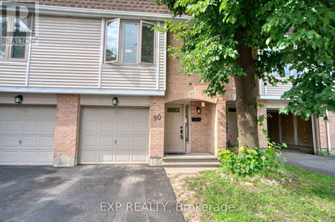 A house with a garage and a tree in front of it.